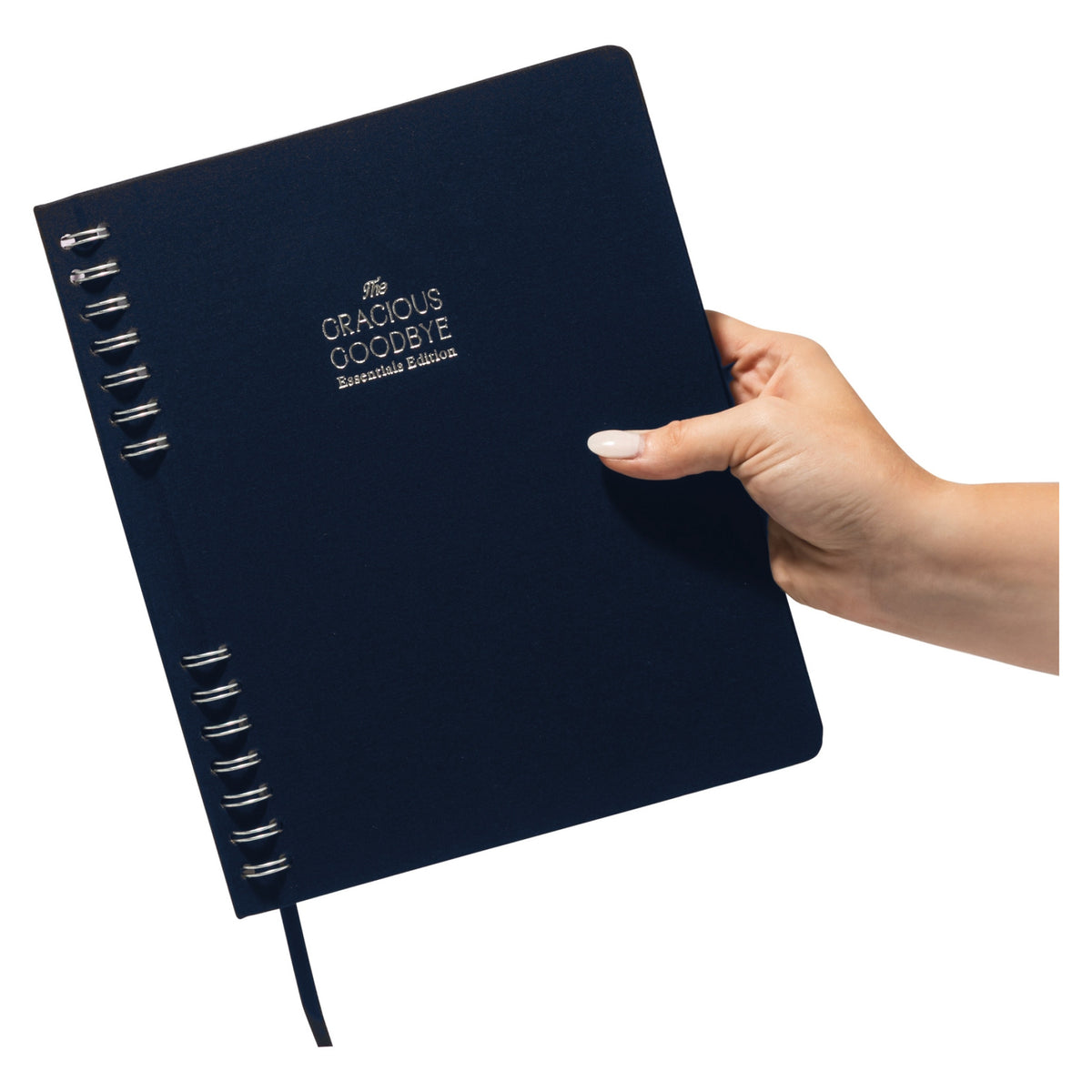 A hand holding the closed navy Gracious Goodbye Essentials, showing how compact the B5 planner is.