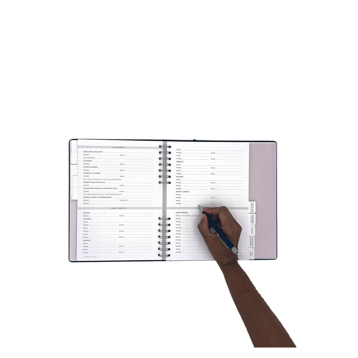 The Gracious Goodbye Essentials open flat with a hand writing on the right page, the concealed spiral visible at the gutter.