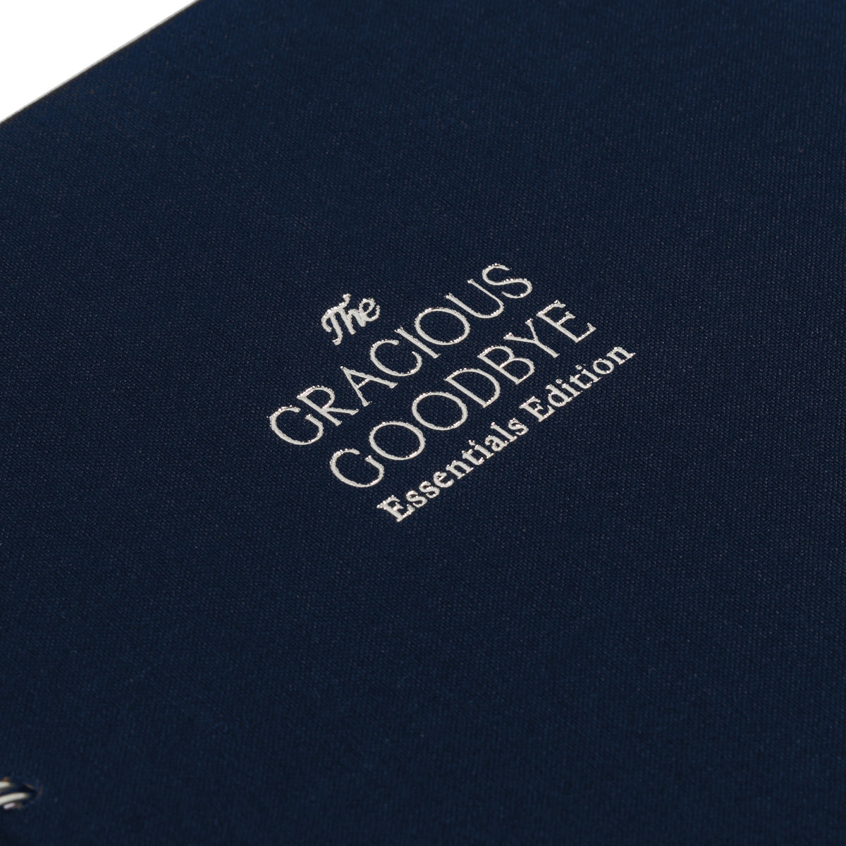 Close-up of the woven linen cover and silver-foil title on The Gracious Goodbye Essentials.