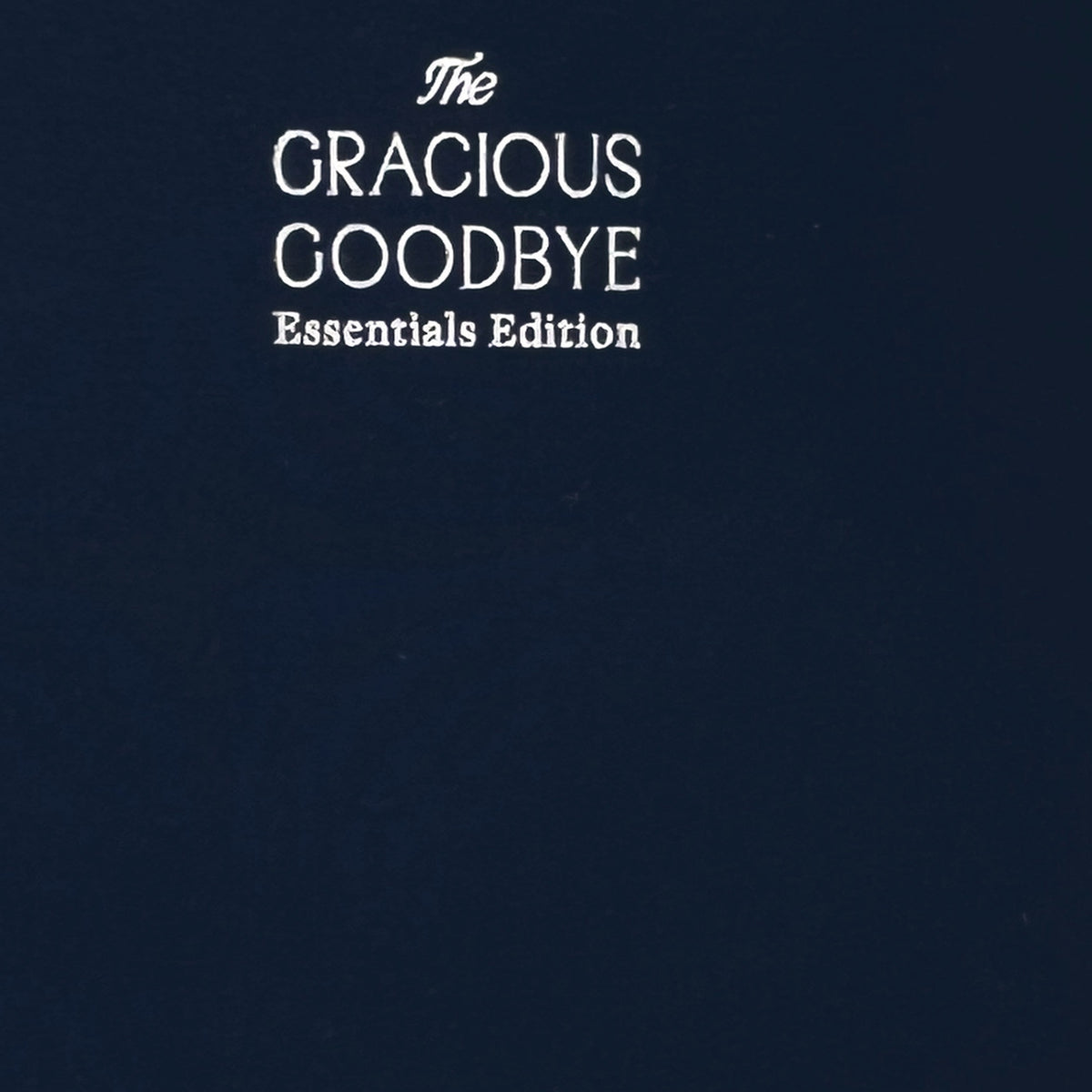 Close-up of the woven navy linen cover and silver-foil title on The Gracious Goodbye Essentials.