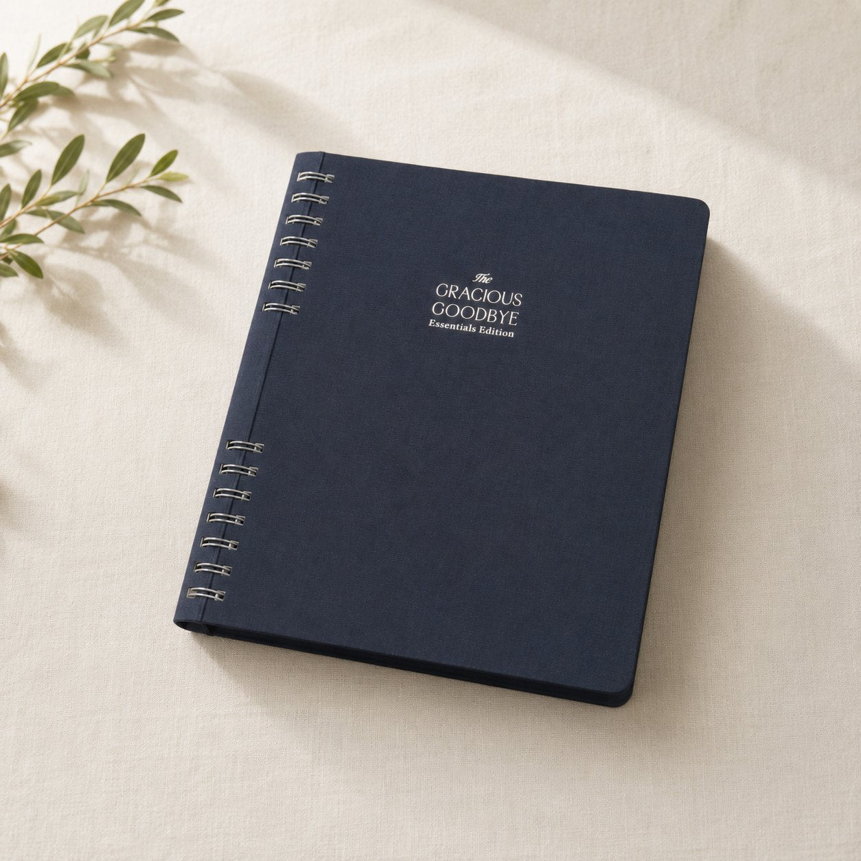 The Gracious Goodbye Essentials simplified end-of-life planner in navy linen, closed, with silver-foil title.