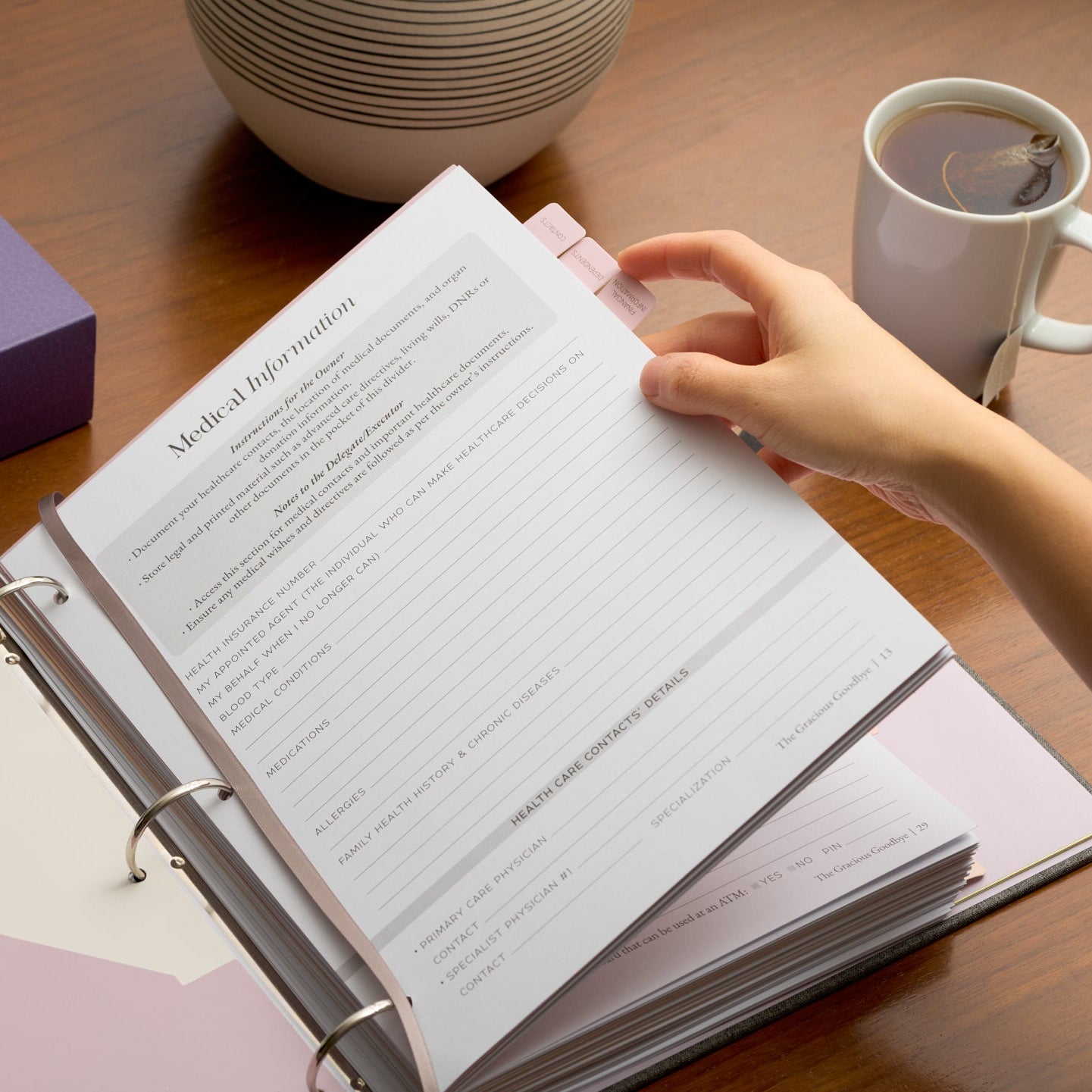 Hands adding a page to the Gracious Goodbye legacy binder's durable, replaceable 3-ring system.